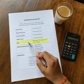Hand pointing at a date on an exam notice, with a calculator and a cup of tea